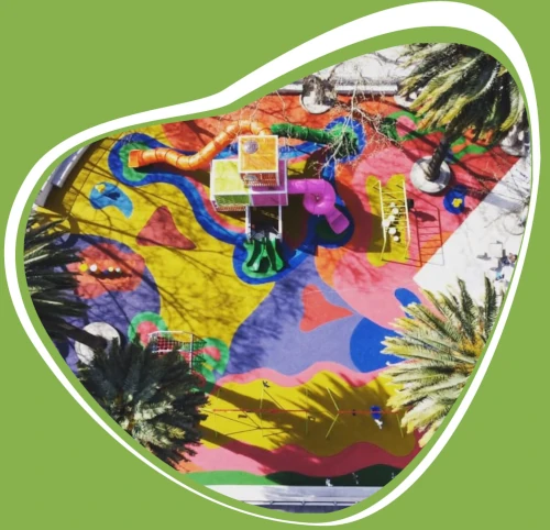 Foto de parque de juegos infantiles vista aerea con pavimento de caucho continuo de múltiples colores y diseños